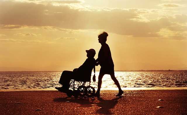 変形性股関節症の看護で海辺で車いすを押す