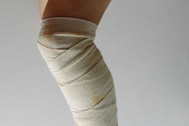 膝の痛みで包帯を巻いた膝